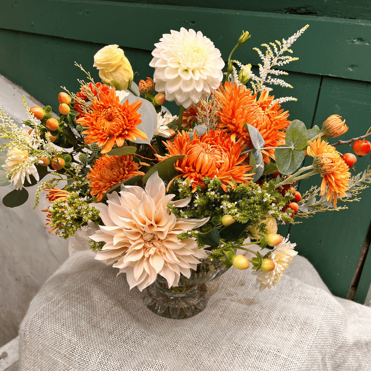 crystal compote with floral arrangement in fall colors and lots of textural elements